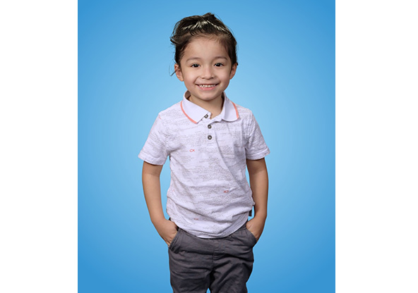 Jonah smiling for his portrait after beating liver cancer